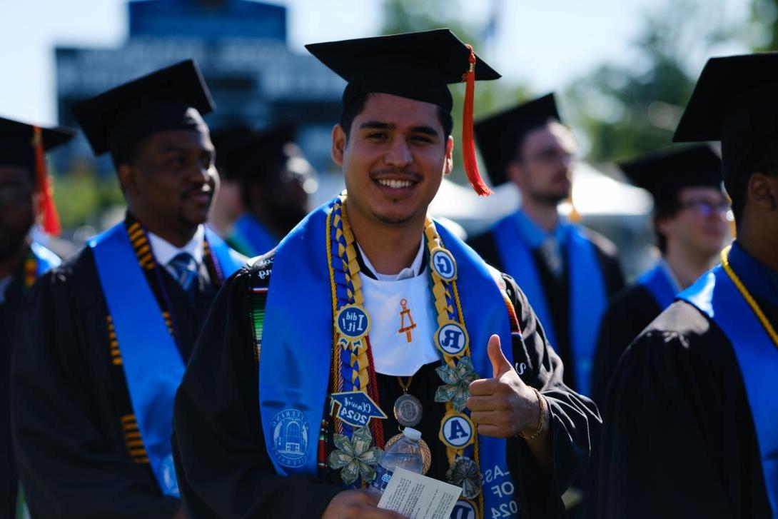 student giving thumbs up at commencement